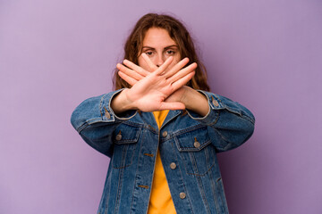 Young caucasian woman isolated on purple background doing a denial gesture