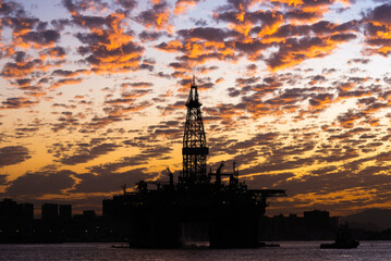 Obraz premium Silhouette of Oil Drilling Rig in Guanabara Bay in Rio de Janeiro, Brazil With Dramatic Sunset Sky