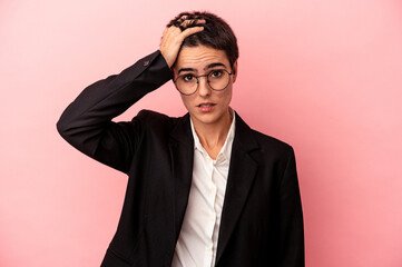 Young business woman isolated on pink background being shocked, she has remembered important...