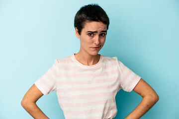 Obraz premium Young caucasian woman isolated on blue background confused, feels doubtful and unsure.