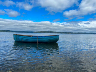 Naklejka premium boat on the beach with blue sky