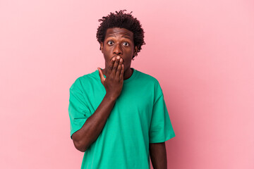 Fototapeta na wymiar Young african american man isolated on pink background shocked, covering mouth with hands, anxious to discover something new.