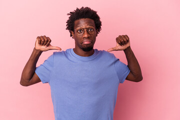 Young african american man isolated on pink background feels proud and self confident, example to...