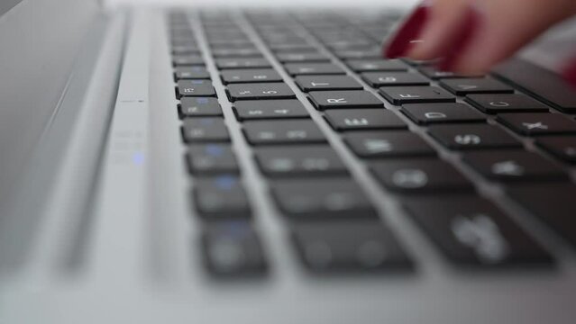 Extreme closeup female fingers with manicure typing on keyboard, selective focus, arc shot. Business woman preparing report, copywriter or blogger writing text. Concept of technology