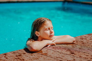Girl in summer bikini posing in the pool with copy space.