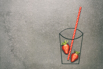 Creative layout with strawberry juice. Sketch of a glass with fresh strawberries and straws. Gray...
