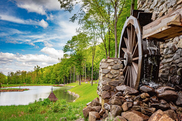 An old stone watermill in a beautiful forest. - obrazy, fototapety, plakaty