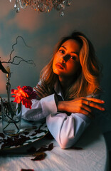 Portrait of attractive caucasian woman sitting at table with candles in the evening.