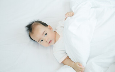 Fototapeta na wymiar Asian baby lying on bed with soft blanket indoors cute little asian newborn baby