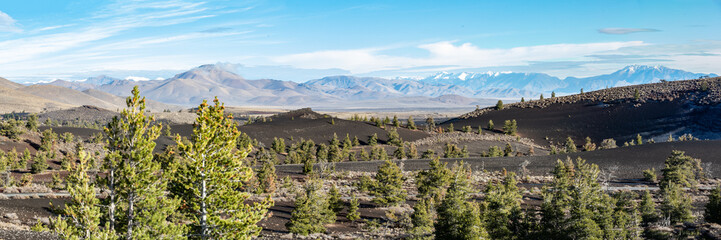Panorama of distant mountains with lava flows of Craters of the Moon National Monument in foreground