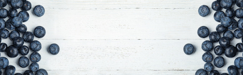 Fototapeta premium Tasty fresh blueberries on white wooden table, flat lay with space for text. Banner design