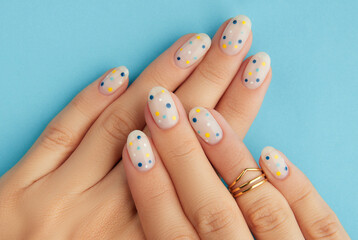 Womans hands with trendy polka dot summer manicure