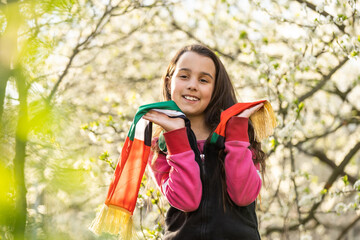 A little girl wearing an emirates flag ribbon