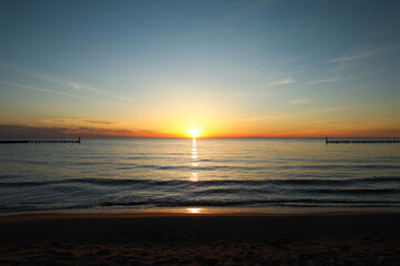 Fototapeta premium Picturesque view of sandy beach and sea at sunset