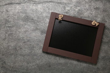 Fototapeta premium Clean small black chalkboard on grey table, top view. Space for text