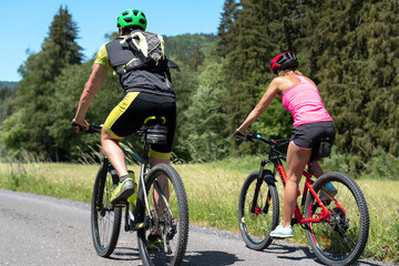 Woman and man riding mountain bikes.