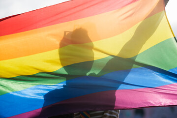 Unrecognizable man silhouette in lgtbi flag - pride day