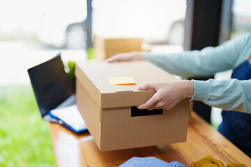Portrait of a business woman, sme packing products in boxes and showing delivery to customers according to their orders