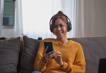relax, de-stress, holiday, happy, Asian woman relaxing at home listening to music from smartphone and laptop happily.