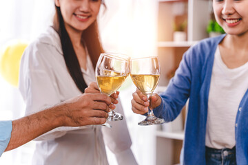 Bravo! group of young people clinking glasses Cheerful enjoying food and drink while together in the office. Focus on the glass.