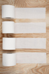 four 4 rolls of toilet paper on a light wooden background unwound place for text or inscription