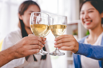 Bravo! group of young people clinking glasses Cheerful enjoying food and drink while together in the office. Focus on the glass.
