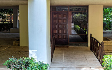 Contemporary residential building exterior entrance wooden door, Athens, Greece.