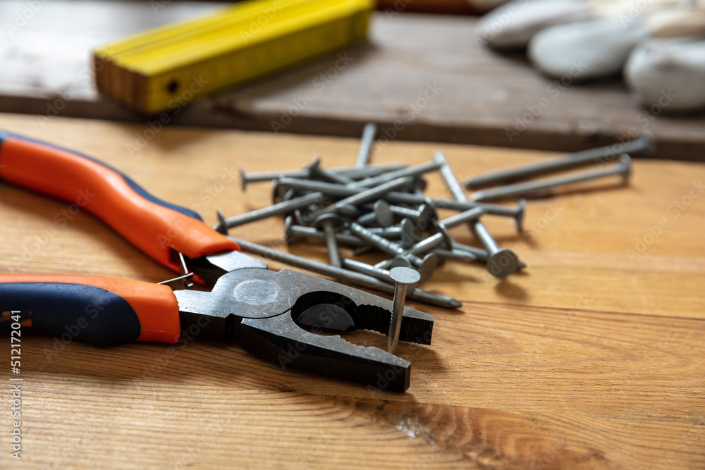 Sticker pliers and nail stack on wood. carpenter work bench table, joinery workshop