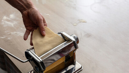 Fresh pasta maker machine. Dough homemade preparation. Hand make dough phylo close up view