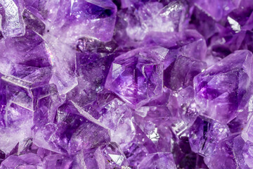 Amethyst purple crystals. Gems. Mineral crystals in the natural environment. Texture of precious and semiprecious stones. Seamless background with copy space colored shiny surface of precious stones.