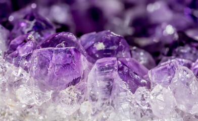 Amethyst purple crystals. Gems. Mineral crystals in the natural environment. Texture of precious and semiprecious stones. Seamless background with copy space colored shiny surface of precious stones.