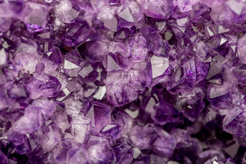 Amethyst purple crystals. Gems. Mineral crystals in the natural environment. Texture of precious and semiprecious stones. Seamless background with copy space colored shiny surface of precious stones.