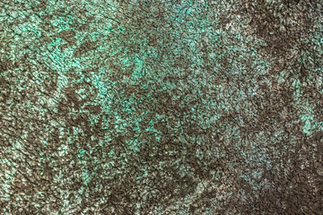 Green background from decorative plaster with abstract spots. Unusual green wall texture with beautiful patterns, creative surface background. Front covering for facing of buildings.