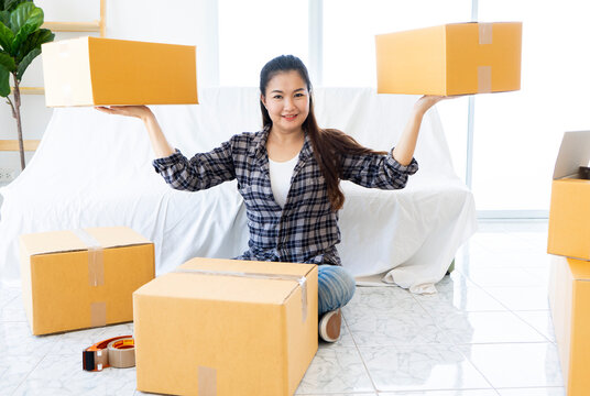 House moving concept. Happy Asian asian woman packing cardboard box
