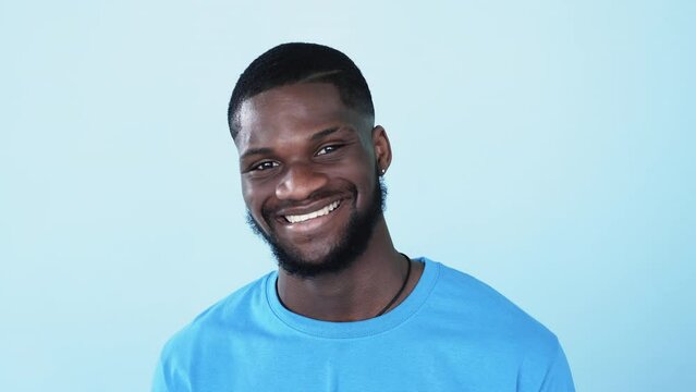 Happy african face. Black people. Positive emotion. BLM racial freedom. Confident cheerful afro man with dark skin white healthy toothy smile isolated on blue copy space background.