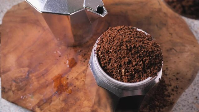 Ground coffee is poured into the moka pot.