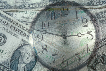 Close-up of a clock superimposed over American dollar bills