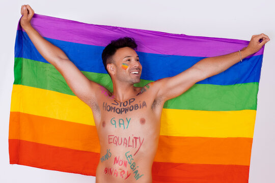 Gay man with Pride flag, and painted words claiming his rights. High quality photo