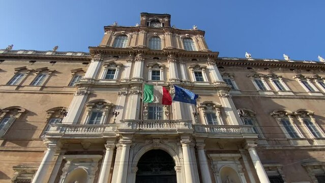 Italian and European flags waving in the wind of the facade of goverment palace