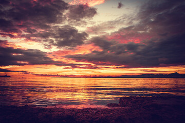 Relax atmosphere. Fiery sunset on the coast. View of the sunset on the sea, El Arenal, Mallorca. Bright saturated sunset on the sea and a rocking boat on the waves, Mallorca, Spain.