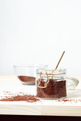 Red quinoa grains in a glass jar.
