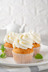 Delicious vanilla cupcakes with cream cheese and sugar candy on a gray background. Dessert for birthday. selective focus, copy space.