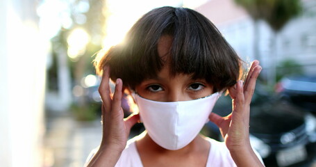 Happy boy removing covid-19 coronavirus face mask outside in sunlight smiling feeling relief