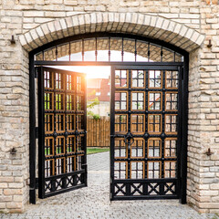 Beautiful medieval wooden gate with stone arch in old weathered building