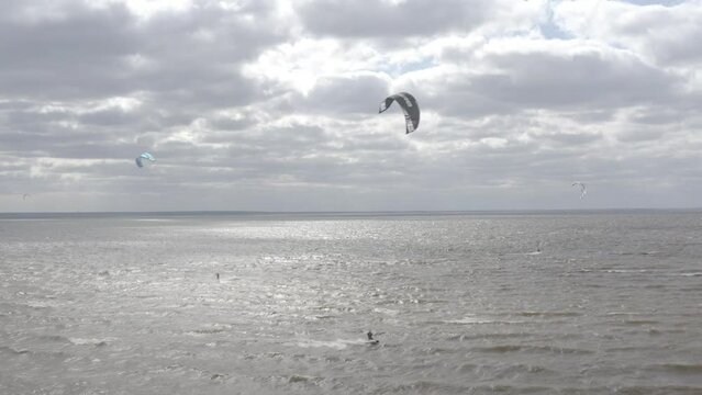 Ukraine. Kyiv. Athletes ride kite surfin. Kiev sea. Summer. Windy weather. Competition. Colored sails. Aerial.