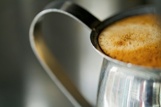 Steaming pitcher full of espresso and steamed milk.