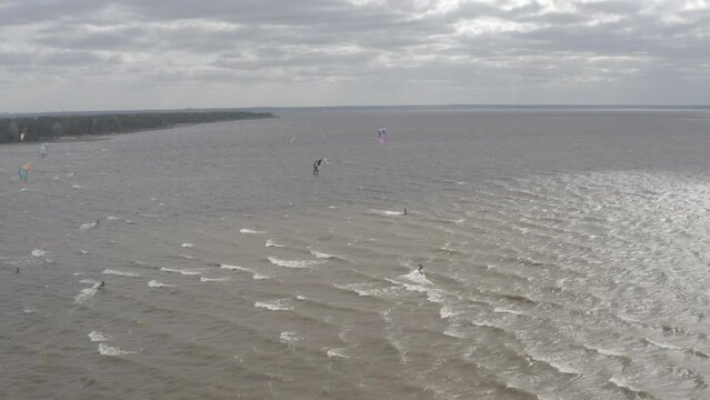 Ukraine. Kyiv. Athletes ride kite surfin. Kiev sea. Summer. Windy weather. Competition. Colored sails. Aerial.