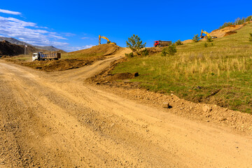 Mining ore, excavator, truck and country road in the mountains.