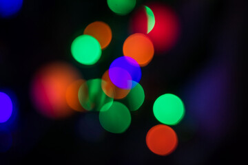 Multi-colored lights on the dark background. The whole shot is strong defocused to use bokeh simulation.