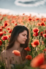 Young girl in the poppy field. Woman in the coutryside at the summer